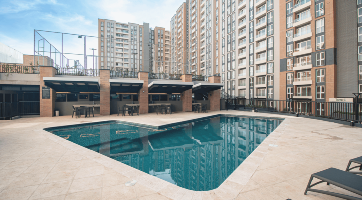 Luxury outdoor infinity pool at Parque Mateo with modern residential towers, cabanas, and social areas in Guatemala City